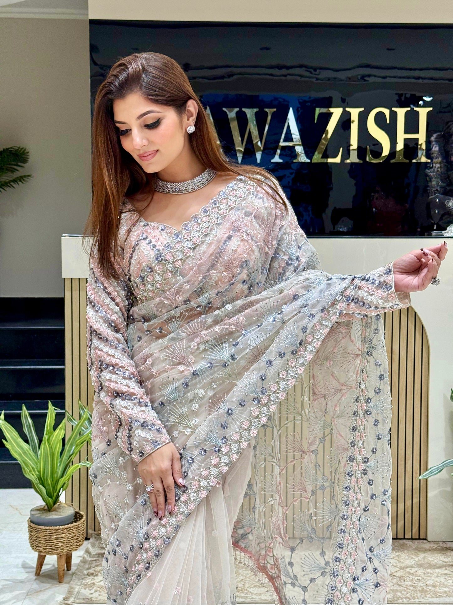 Stylish drape of silver net saree with delicate handcrafted detailing, paired with a couture-style embellished blouse for luxurious Indian wedding looks.