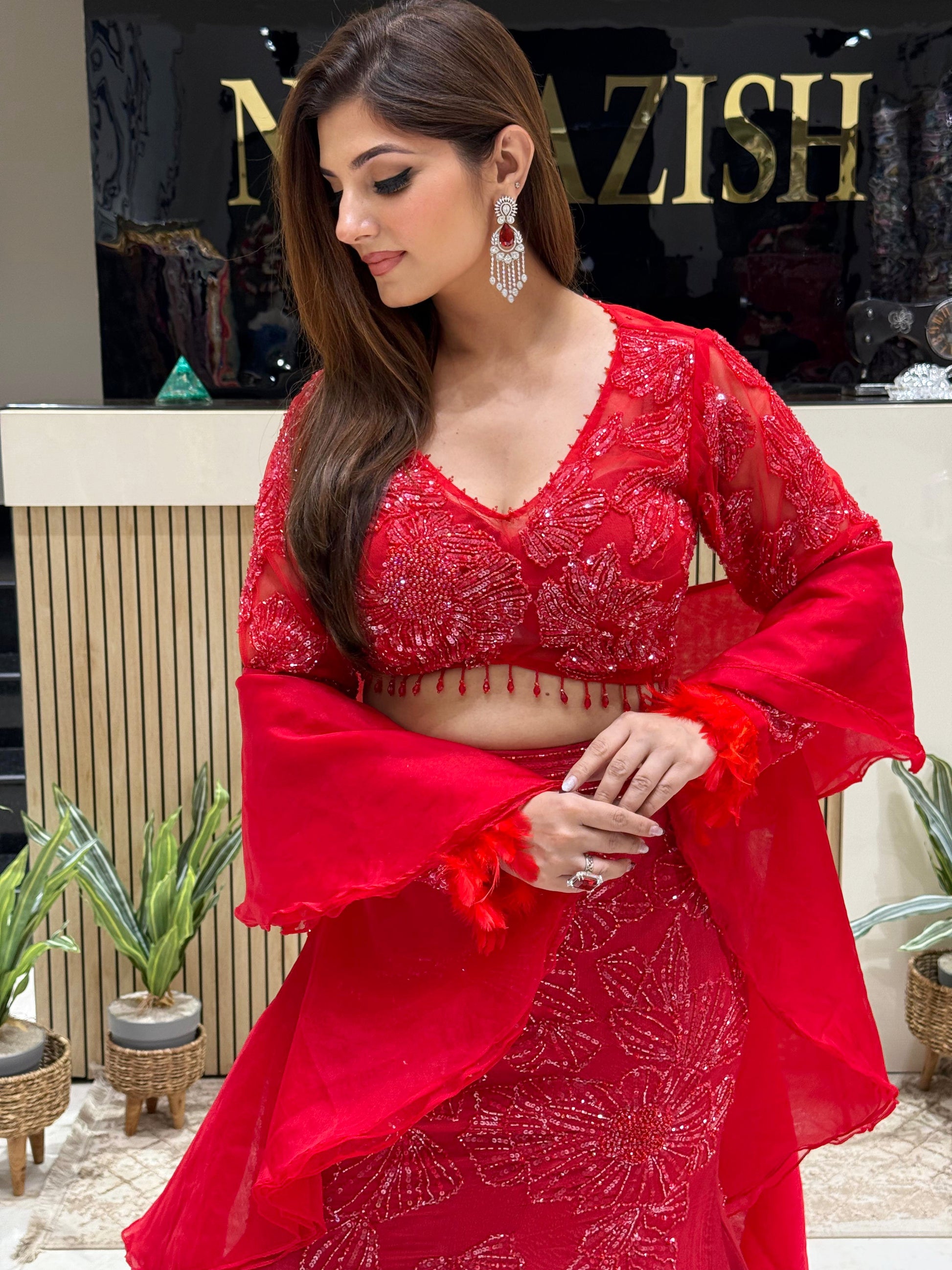 Hand-embroidered red lehenga with figure-flattering cut and stylish ruffle dupatta for Indian weddings.