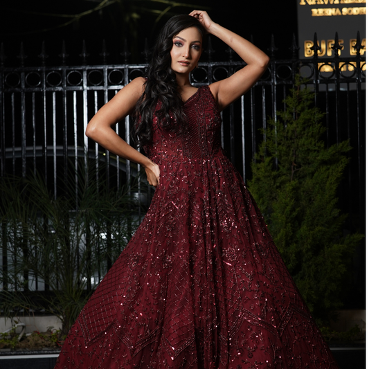 Turn heads in this hand-embellished maroon bridal gown, a luxurious creation from Nawazish designed for brides who love timeless glamour. Crafted with detailed Zardozi and Dabka embroidery on a rich maroon base, this gown exudes regal charm—perfect for your wedding reception, sangeet, or bridal photoshoot.