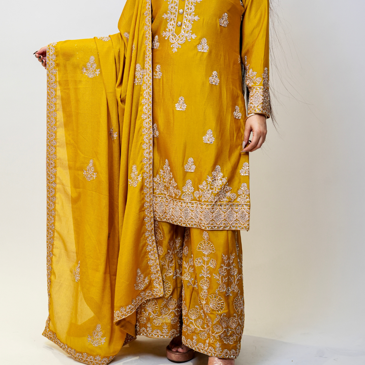 Bright, bold, and beautifully embellished—this mustard Sharara suit is a celebration of tradition and couture craftsmanship. Designed for festive occasions, weddings, and pre-wedding functions, it pairs timeless embroidery with a rich, vibrant hue. A true Nawazish classic.