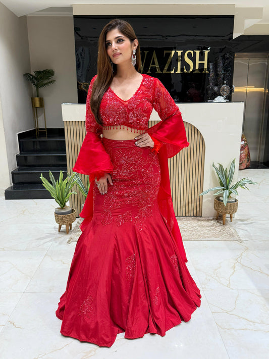 Red fish-cut lehenga with detailed hand embroidery and ruffle dupatta, perfect for brides and wedding guests.