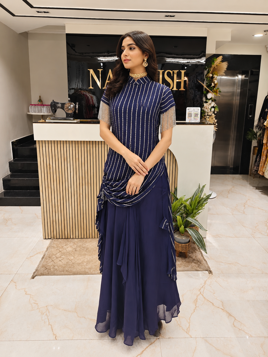 Woman in a blue dress standing in a modern interior setting with 'Nautish' branding.