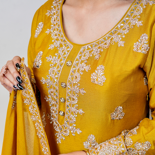 Bright, bold, and beautifully embellished—this mustard Sharara suit is a celebration of tradition and couture craftsmanship. Designed for festive occasions, weddings, and pre-wedding functions, it pairs timeless embroidery with a rich, vibrant hue. A true Nawazish classic.

