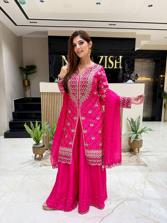 Hot pink raw silk Sharara suit with intricate hand embellishments on the shirt, perfect for brides and wedding guests.