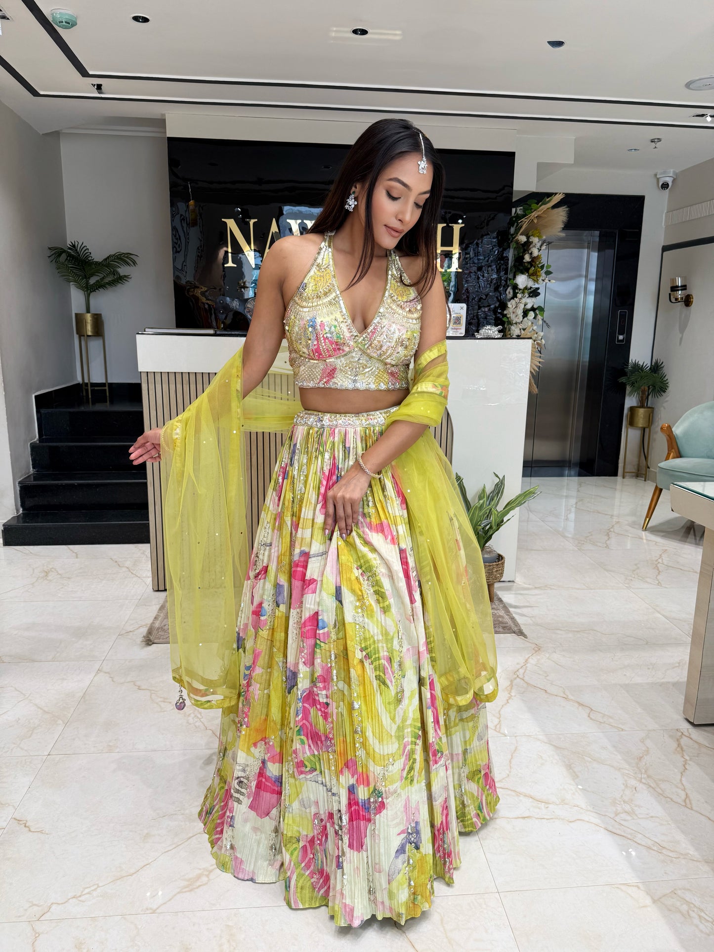 This lightweight yellow lehenga with floral prints and an intricately detailed blouse is designed for effortless elegance at day weddings and festive occasions.