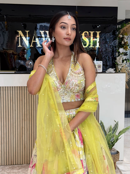 A refreshing lime yellow floral lehenga set featuring a hand-embroidered blouse and flowy pleated skirt, paired with a sheer cape dupatta—perfect for haldi and mehendi celebrations.