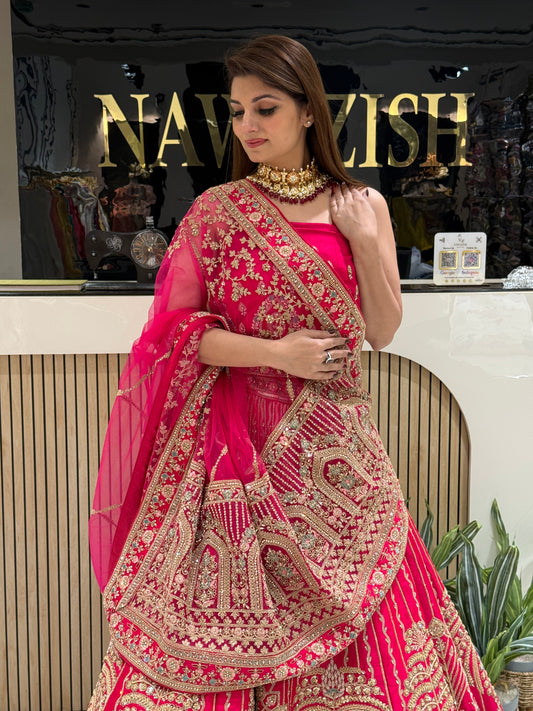 Rani Pink bridal lehenga in Raw Silk with double net dupatta
• Designer bridal lehenga with machine work and heavy border dupatta
• Luxury wedding lehenga for brides with unstitched matching blouse
• Stylish bridal wear lehenga with two net dupattas and booti work
• Royal Raw Silk bridal lehenga perfect for wedding and reception wear