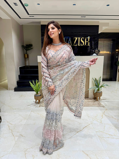 Elegant silver net saree with all-over hand embellishments, styled with a matching heavily embroidered designer blouse for bridal and evening wear.