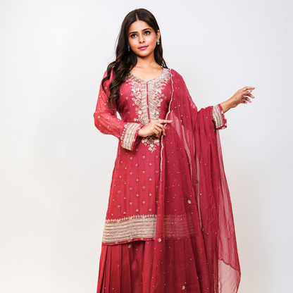 Elevate your ethnic wardrobe with Nawazish’s signature rose pink Sharara suit, handcrafted in rich fabric with all-over embellishment and a beautifully detailed neckline. The flowing sharara adds a festive flair, while the embroidery lends timeless charm. Ideal for the bride’s sister, bridesmaids, or anyone looking for elegant occasion-wear with artisanal appeal.