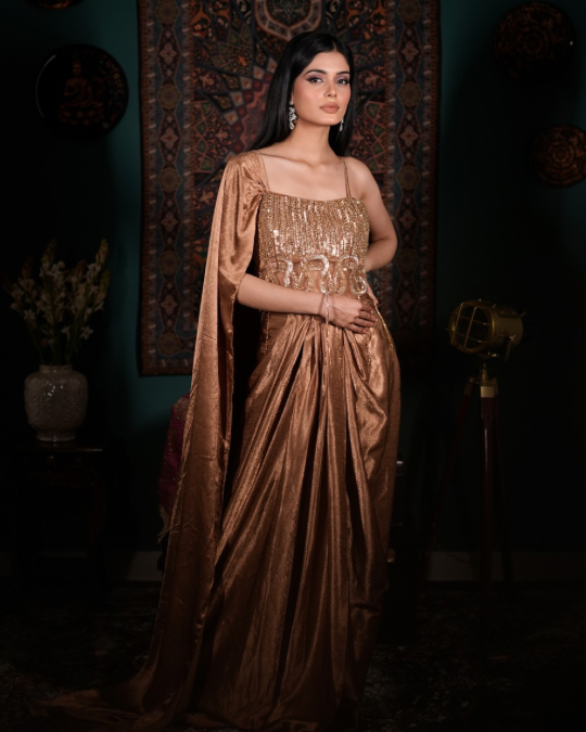 [Elegant gold couture outfit, Handcrafted crystal detailing, Chic Indo western ensemble, Modern ethnic glamour, Designer drape skirt look]