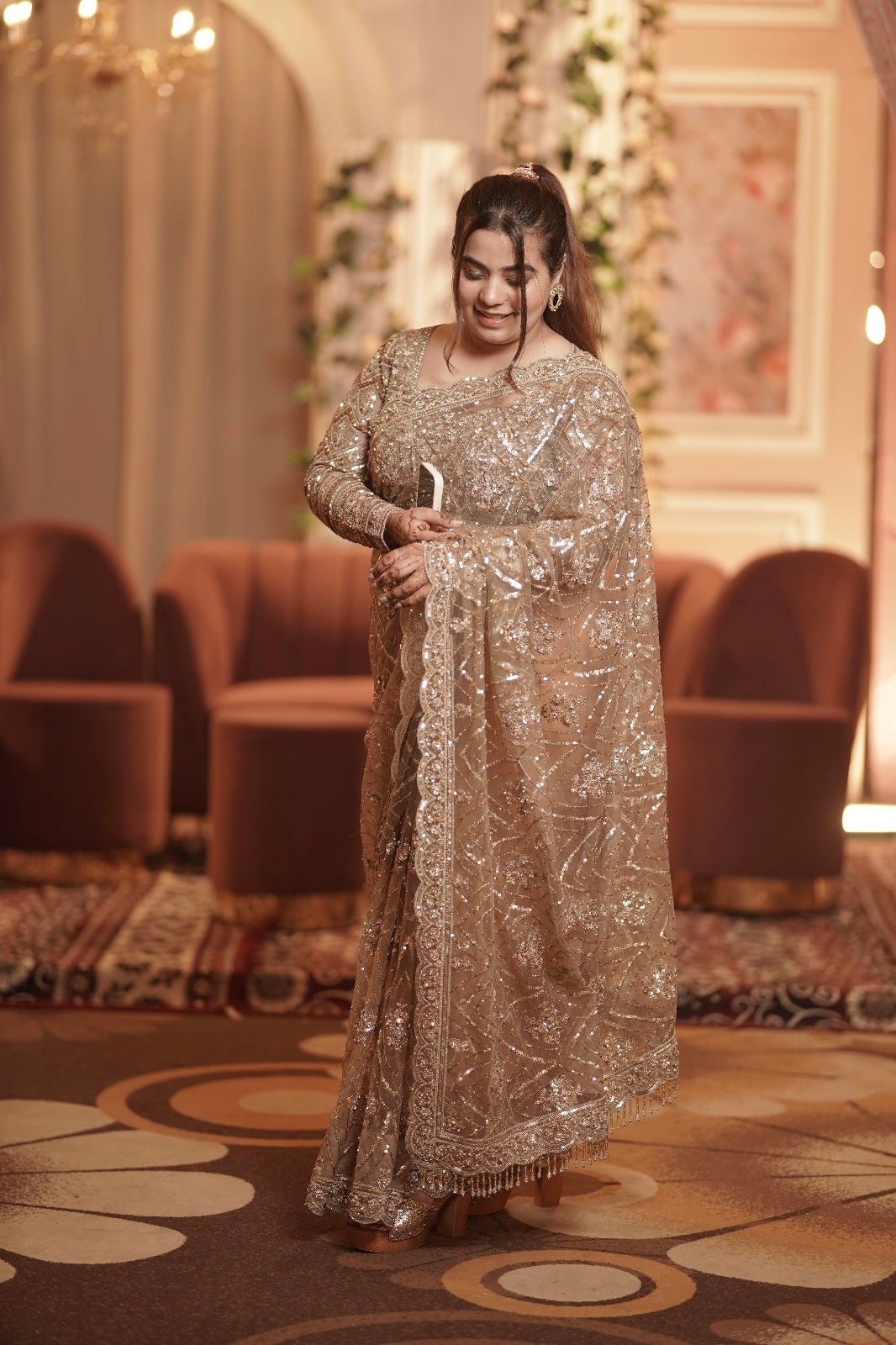 A vision of elegance, our stunning client—the sister of the groom—radiates grace in a champagne gold hand-embroidered sari from Nawazish. Crafted with delicate detailing and luxurious fabric, this designer sari is the perfect balance of subtle glamour and refined tradition.
At Nawazish, we offer couture-inspired pieces for every role in the celebration. Whether you're the bride, bridesmaid, or sister of the groom, our hand-embroidered saris and custom ensembles ensure you feel just as special. Discover timeless fashion, beautifully made for every woman, every celebration.