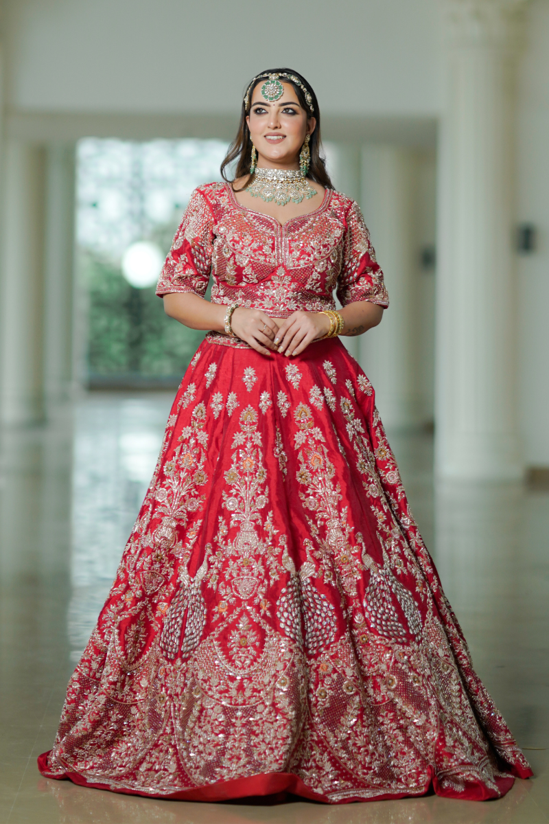 Discover the widest variety of red bridal lehengas at Nawazish, featuring timeless hand embroidery in Zardozi and Dabka. Each lehenga is a masterpiece of royal design, crafted in luxurious fabrics with intricate detailing for the modern Indian bride. From deep maroons to classic bridal reds, our collection celebrates heritage craftsmanship, regal charm, and couture elegance in every thread.
