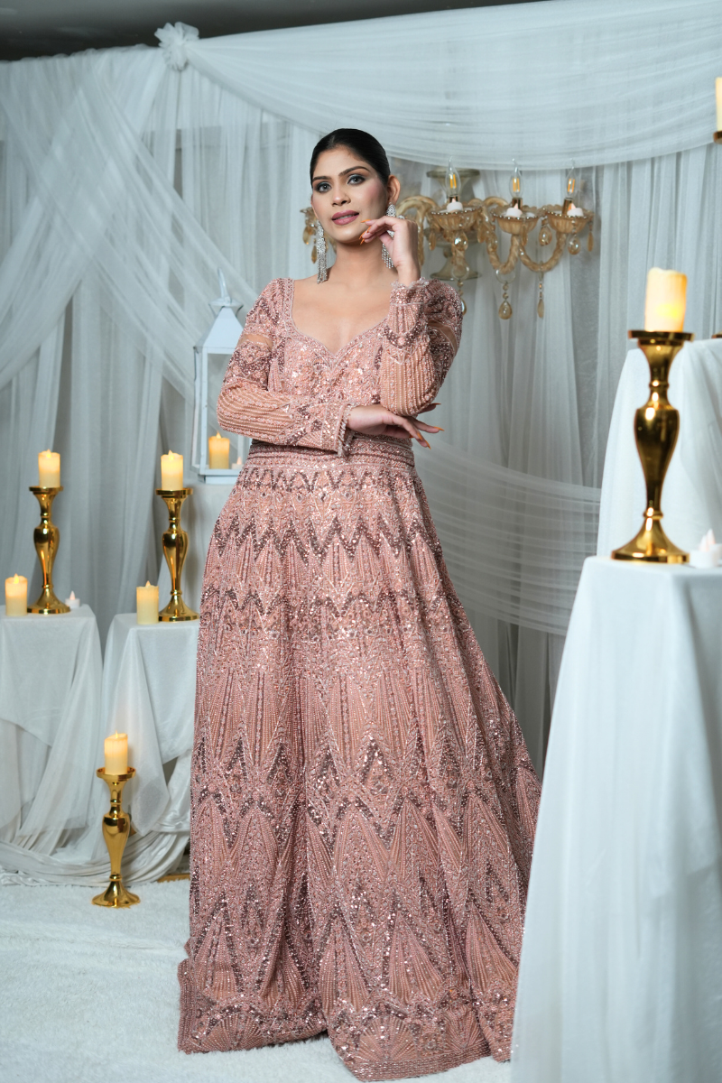 Luxurious rose pink bridal gown by Nawazish featuring intricate tone-on-tone hand embellishments and detailed embroidery. Perfect for Indian brides seeking a soft, romantic palette with refined craftsmanship. Ideal for wedding day, reception, or bridal photoshoots with an elegant ethnic flair.